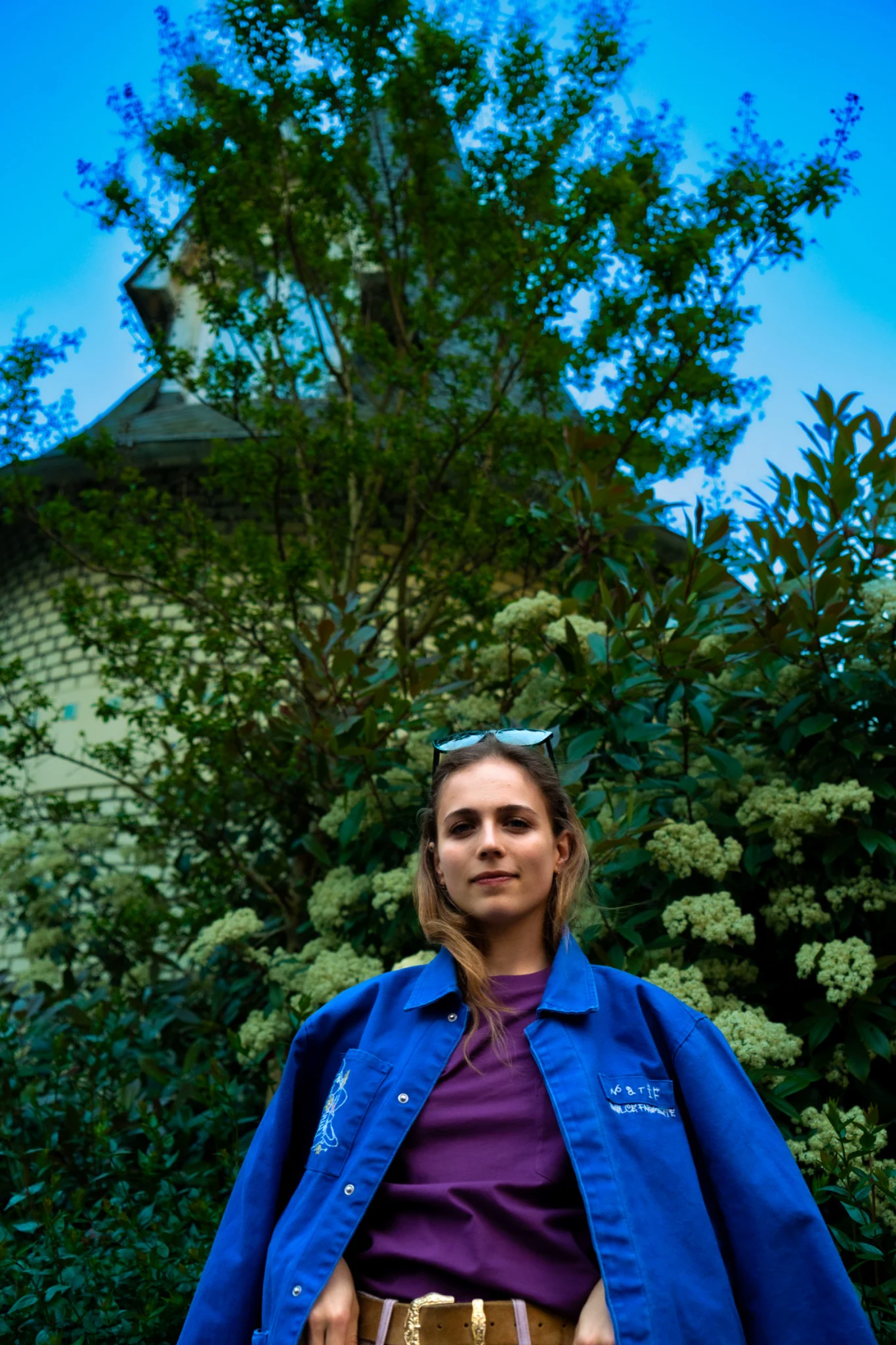 Portrait en contre-plongée portant une veste bleue Natif devant la végétation